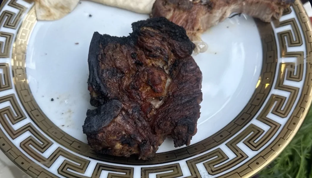 Фото тарелки с мясом на гриле в видоискателе камеры